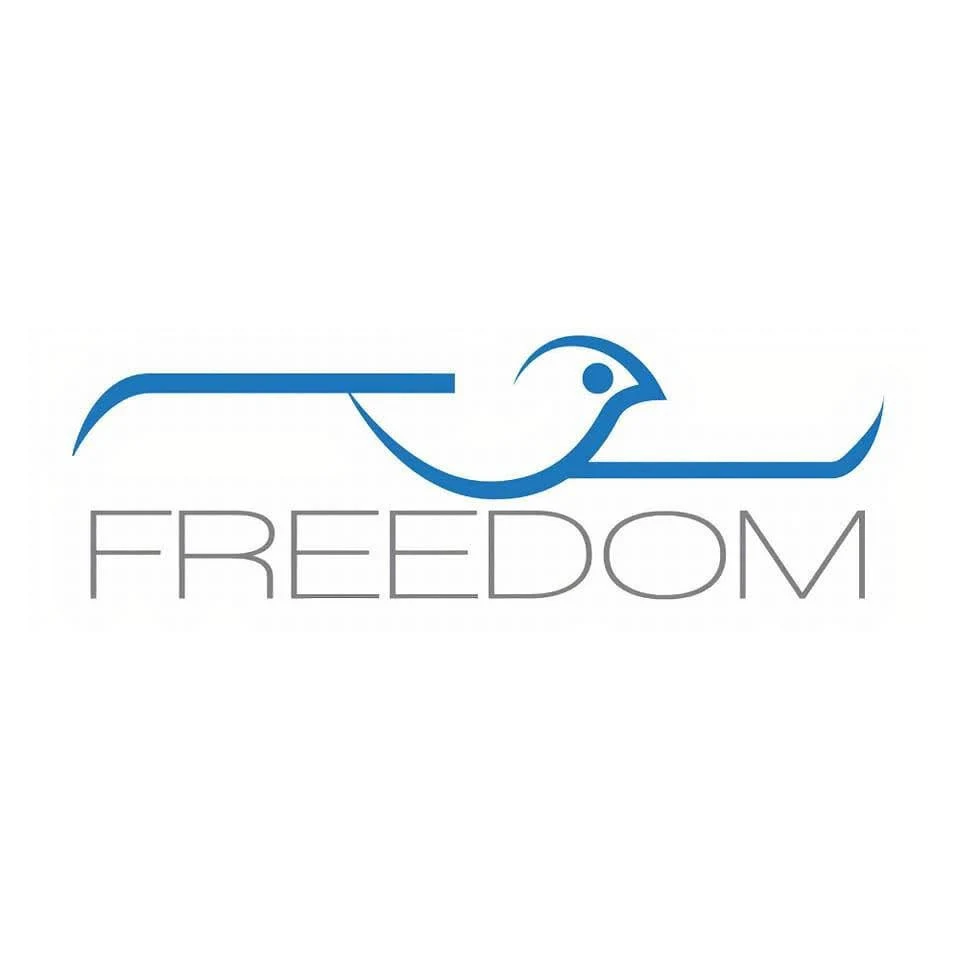 شعار مراكز الحرية لعلاج الإدمان والطب النفسي: طائر أزرق منطلق فوق كلمة FREEDOM